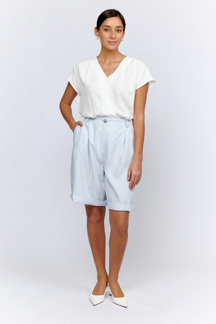 Шорты свободного силуэта с двумя складками на поясе. Длина до колен. Застежка на пуговицу и молнию.