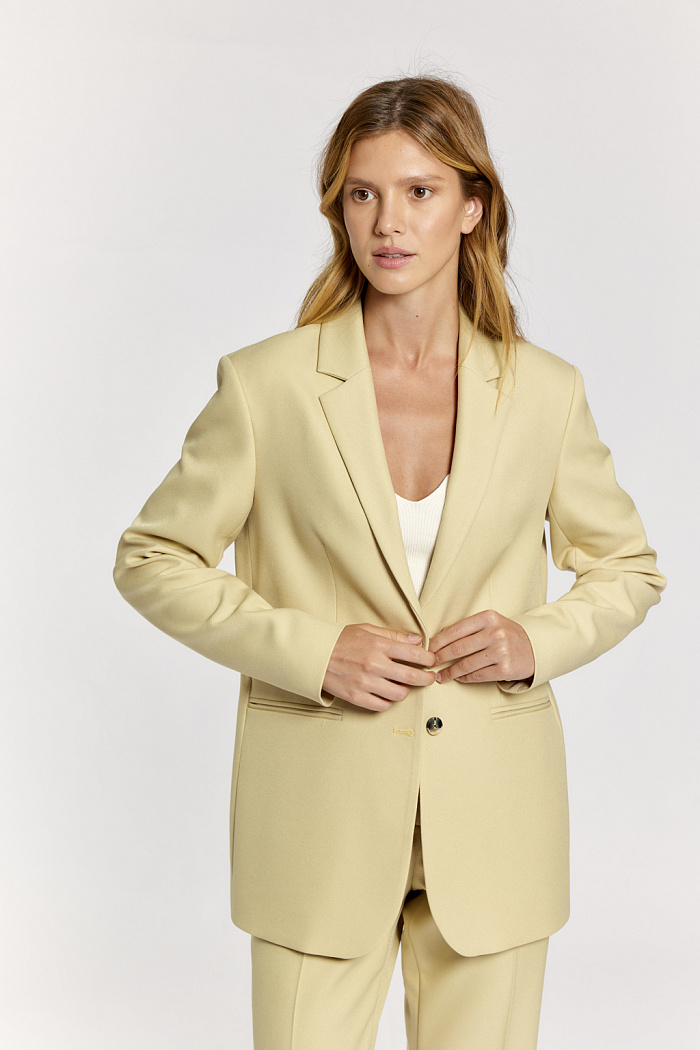 Жакет полуприлегающего силуэта с застежкой на две пуговицы с английским воротником. Длина до бедер.