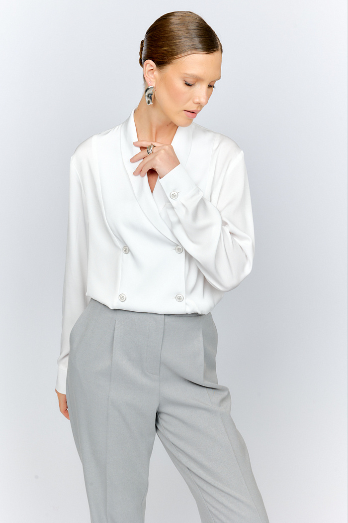 Двубортная блузка свободного кроя из струящейся блузочной ткани в осеннем теплом оттенке кэмел, с шалевым воротником, с разрезами по бокам. Может сочетаться с юбками и брюками из коллекции и носиться навыпуск и под заправку.