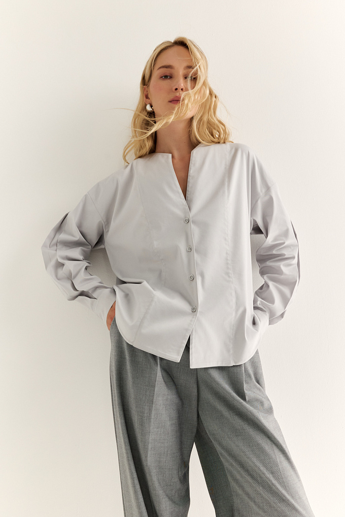 Блуза с V-вырезом: нежность в современном ритме. Эта блуза сочетает в себе деликатность форм и продуманную простоту. Глубокий V-образный вырез визуально вытягивает силуэт, а мягкие линии кокетки и рукавов добавляют романтичности. Объёмные рукава с манжетами и аккуратная застёжка на пуговицы завершают образ с лёгкой винтажной ноткой. Идеально смотрится в паре с юбками на высокой талии, широкими брюками или под жилет. Благодаря универсальному дизайну легко вписывается как в деловой, так и в вечерний гардероб. Лёгкость, которая подчёркивает внутреннюю силу.