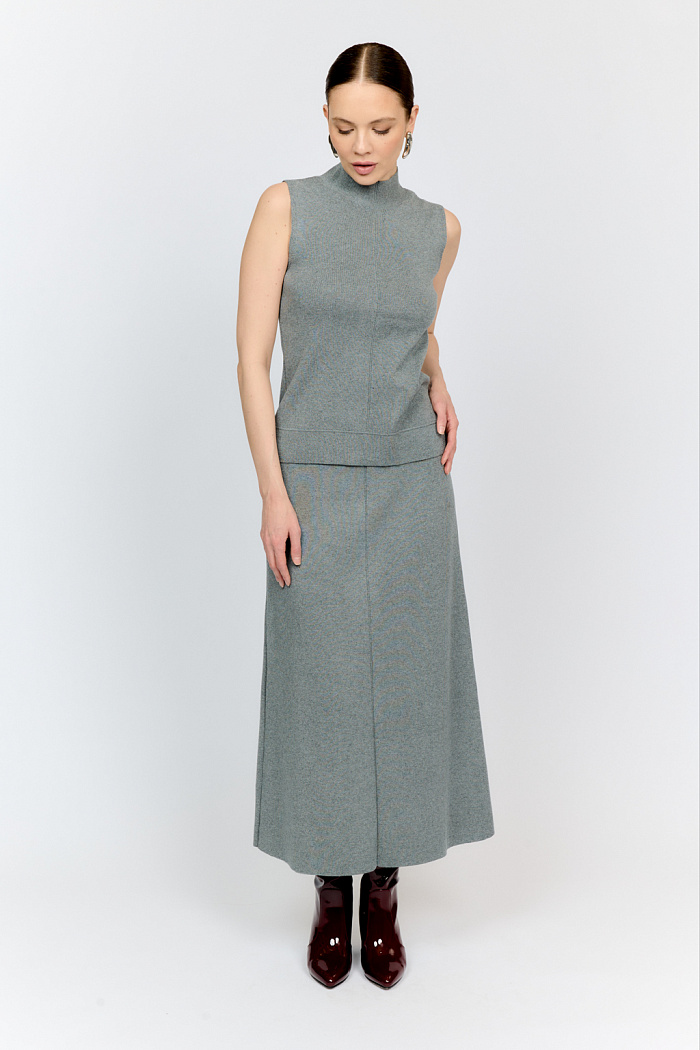 Юбка серого цвета силуэта трапеция длиной миди с завышенной талией подчеркивает природную женственность фигуры. Фасон с расклешением к низу визуально стройнит бедра и корректирует фигуру, зрительно удлиняет ноги. Хорошо сочетать с приталенными джемперами и топами из аналогичной пряжи.