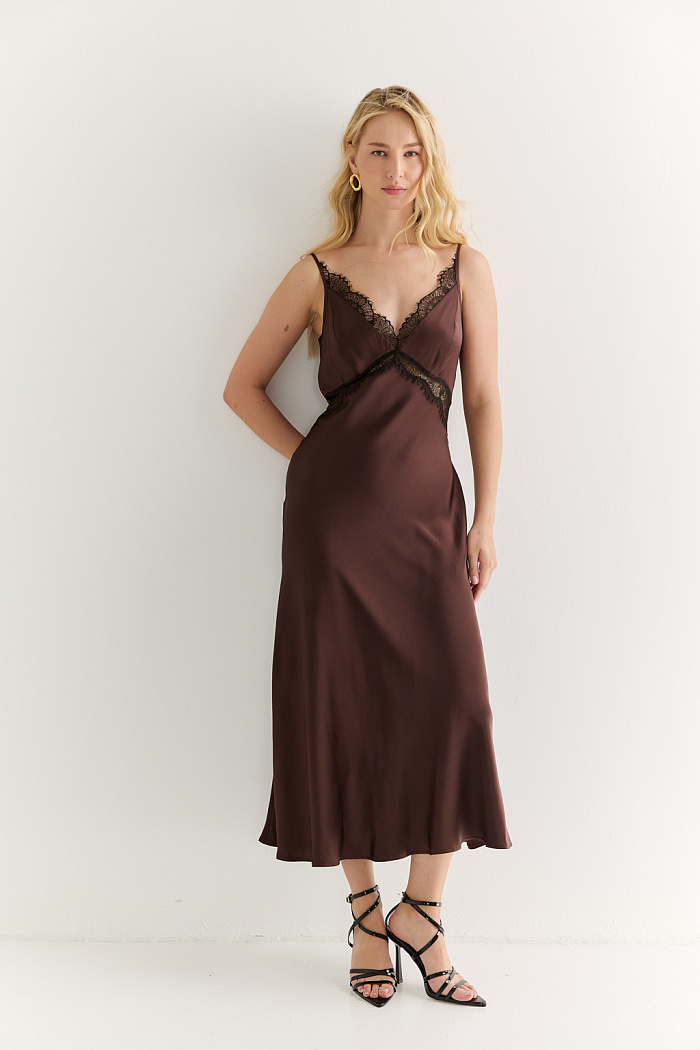 Платье-комбинация на тонких бретелях с декоративной отделкой кружевом цвета горького шоколада длины мидакси. Скроено по косой. Выполнено из струящейся ткани из вискозы.  Вискоза придает ткани мягкость, пластичность и легкий благородный блеск. Район обеспечивает струящуюся фактуру и комфорт в носке. Преимущества ткани: деликатный матовый перелив, создающий утонченный акцент на контрасте с кружевом. Ткань хорошо драпируется, формируя мягкие и чистые линии силуэта. Натуральная основа обеспечивает комфорт. Струящееся силуэтное платье можно дополнить блузами из тенселя для создания легкого женственного образа или добавить строгости комбинируя с жакетами.