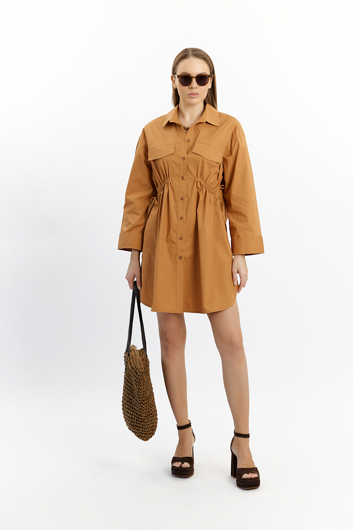 Платье-рубашка с декоративной кулиской в передней части и двумя накладными клапанами. Застежка на пуговицах. Длина мини.