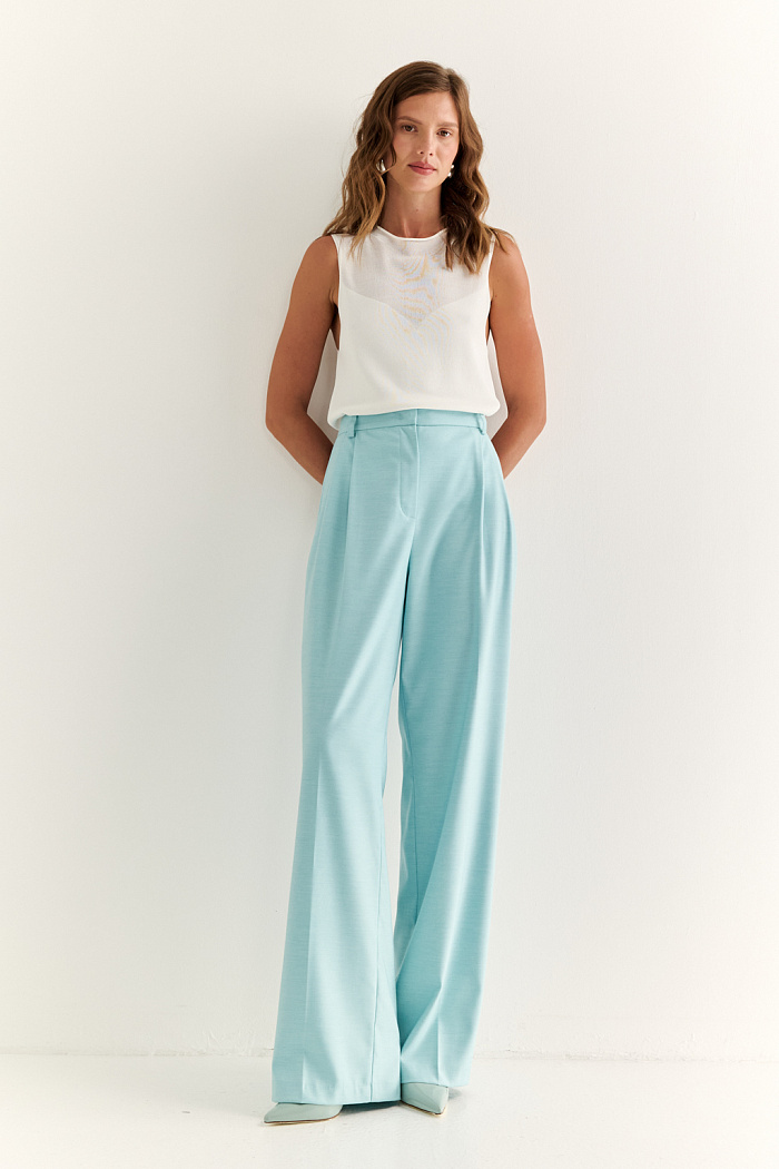 Прямые брюки со складками: точность линии и лёгкость движения

Классические прямые брюки со складками — это гармония формы и свободы. Мягкие складки от пояса придают объём в нужных зонах, создавая лёгкий акцент на талии и обеспечивая комфорт в движении. Прямой силуэт визуально вытягивает фигуру и делает образ стройнее и собраннее.

Идеальны для деловых комплектов, а также легко вписываются в повседневный гардероб. Сочетаются с жакетами, рубашками, базовыми топами и обувью любого стиля — от каблуков до лоферов.

Брюки, в которых строгость выглядит расслабленно.