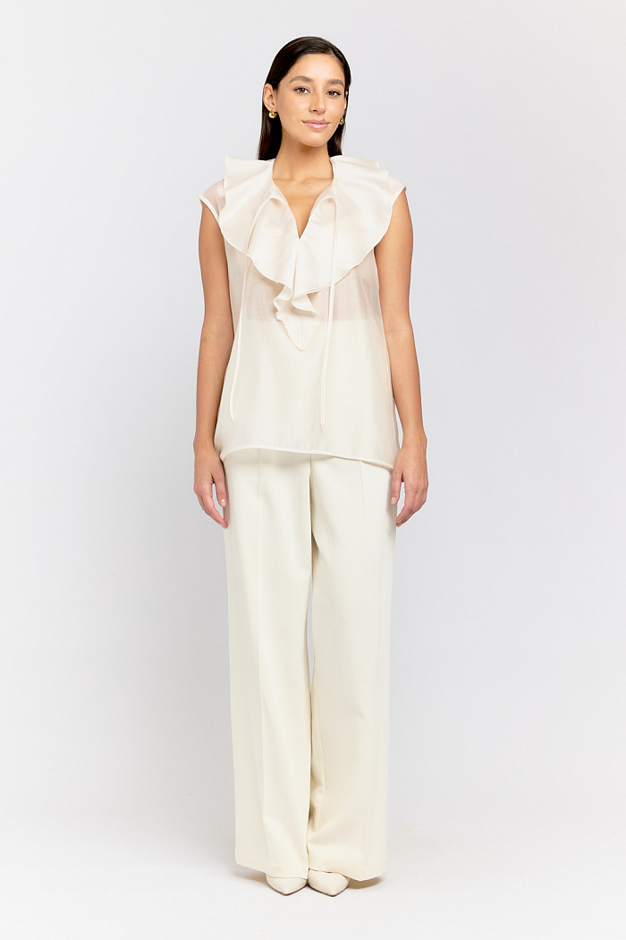 Блуза без рукавов с рюшей на полочке.