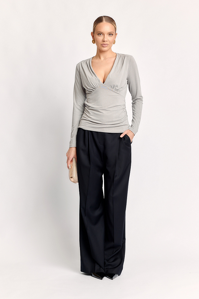 Брюки с защипами свободного кроя полной длины.