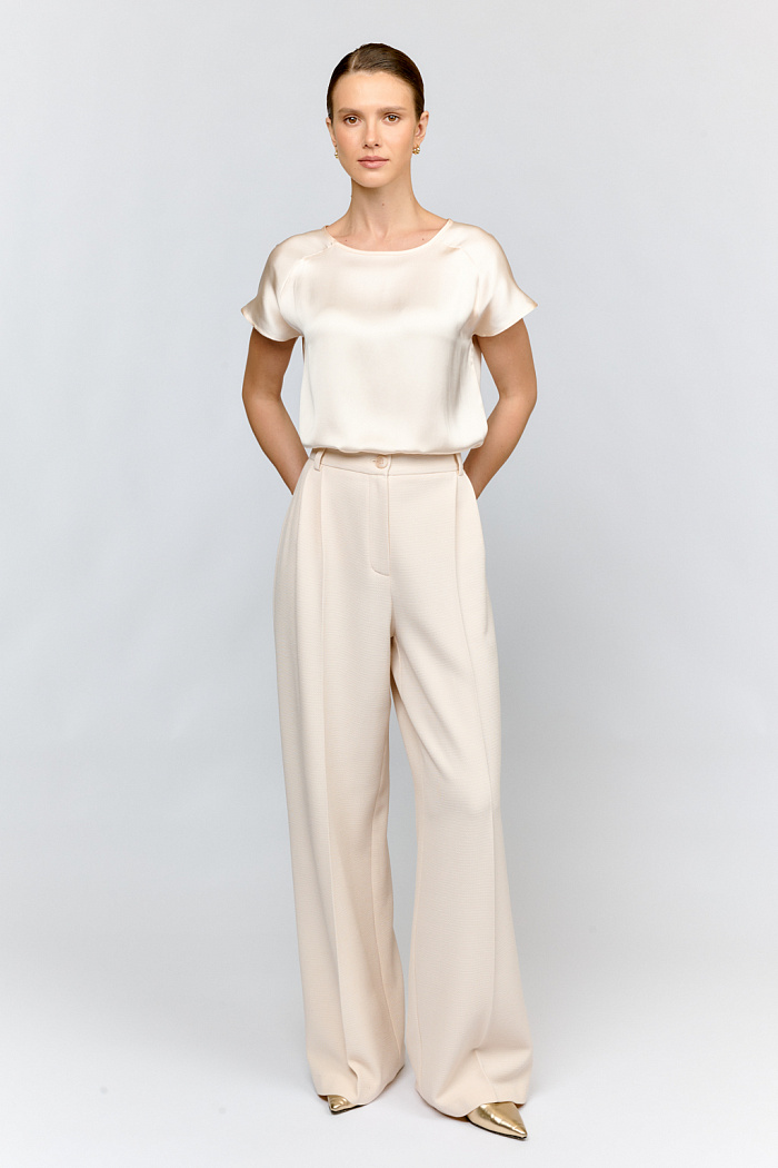 Широкие брюки с двумя элегантными складками на поясе из премиальной ткани цвета экрю. Универсальная модель для делового гардероба. Свободная посадка обеспечивает комфорт в течение всего дня.